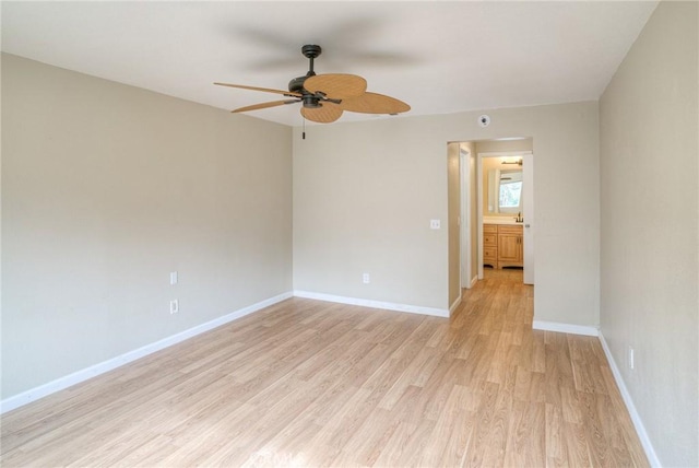 empty room featuring ceiling fan, light wood-style flooring, and baseboards