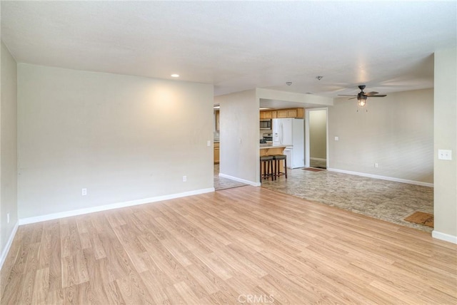 unfurnished living room with recessed lighting, light wood-type flooring, a ceiling fan, and baseboards