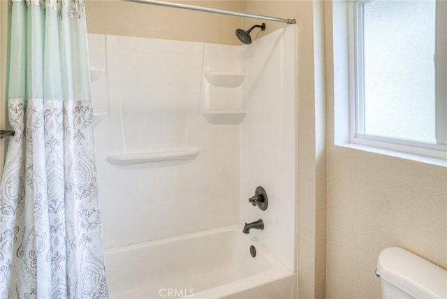 bathroom featuring shower / bath combination with curtain and toilet