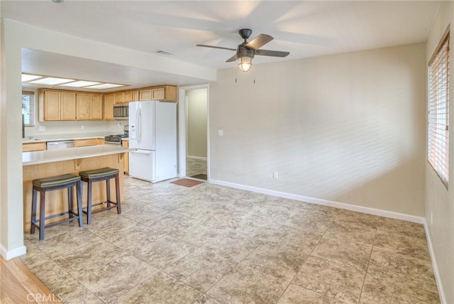 kitchen with visible vents, baseboards, light countertops, appliances with stainless steel finishes, and a kitchen bar