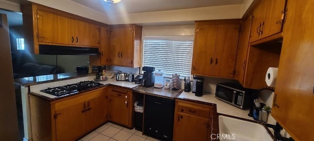 kitchen featuring black gas stovetop, under cabinet range hood, light countertops, brown cabinets, and stainless steel microwave