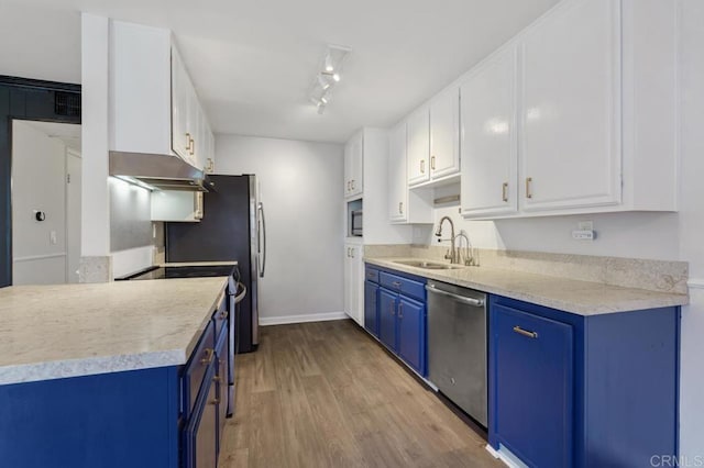 kitchen featuring blue cabinets, white cabinetry, light countertops, and stainless steel dishwasher