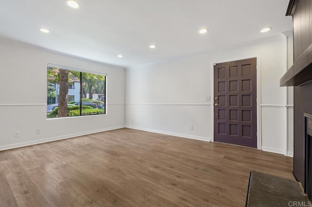 unfurnished living room with a fireplace, wood finished floors, and recessed lighting