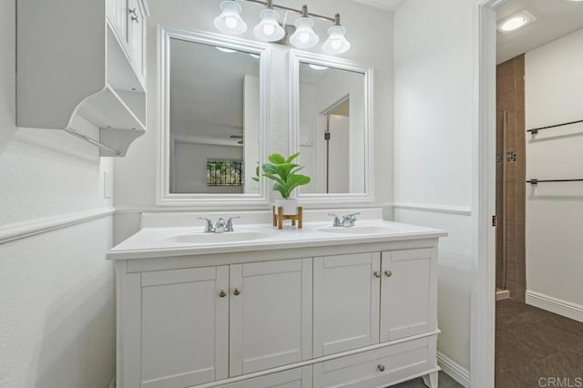 full bath with double vanity, baseboards, and a sink