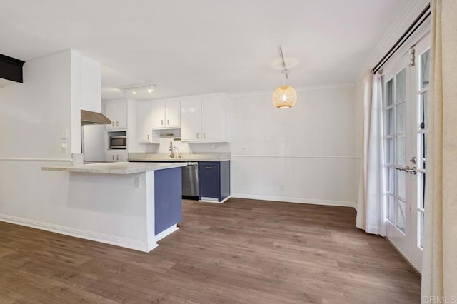 kitchen featuring a peninsula, white cabinets, appliances with stainless steel finishes, a kitchen bar, and pendant lighting