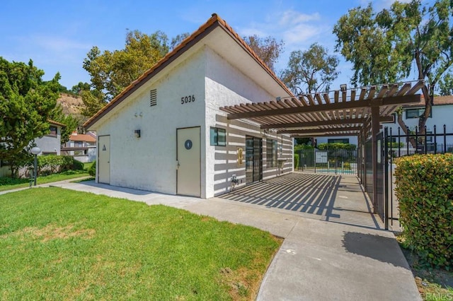 view of side of home featuring a yard, fence, and stucco siding