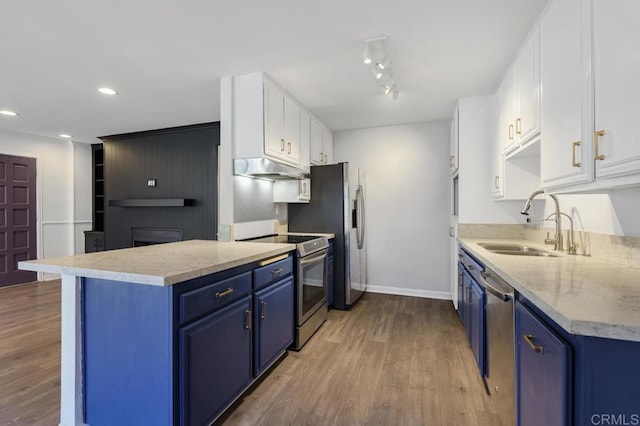 kitchen featuring stainless steel appliances, blue cabinets, light countertops, and white cabinetry