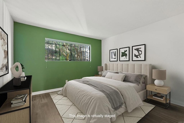 bedroom with baseboards and wood finished floors