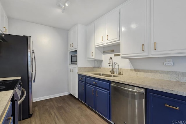 kitchen with stainless steel appliances, a sink, light countertops, and white cabinetry