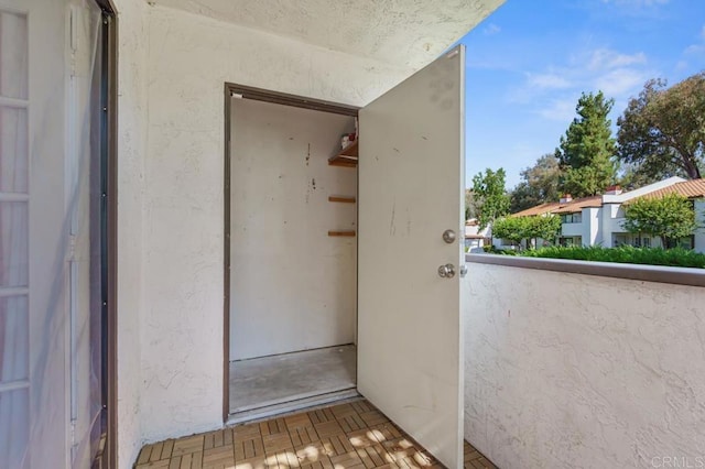 entrance to property with a balcony and stucco siding