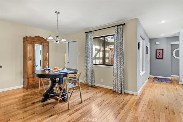 dining room featuring baseboards, an inviting chandelier, and light wood-style flooring