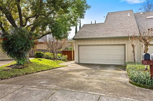 garage with fence and driveway