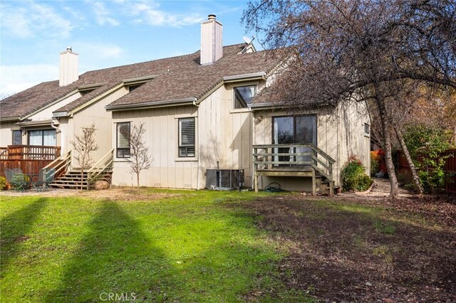 rear view of property with a wooden deck, a chimney, fence, a yard, and central AC unit