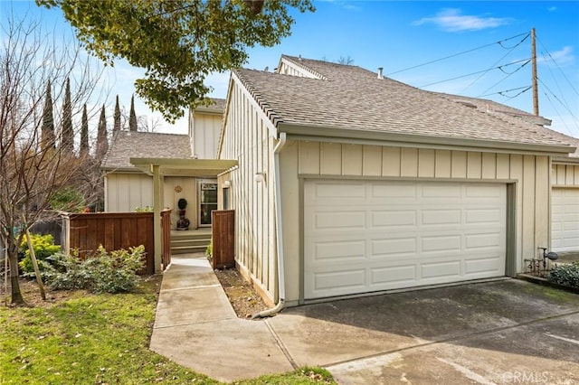 exterior space with roof with shingles and a garage