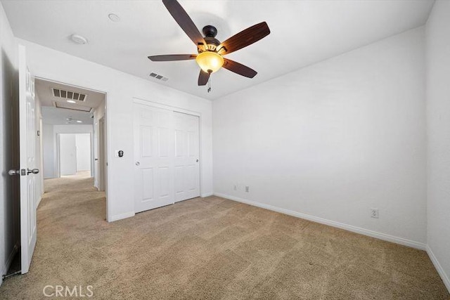 unfurnished bedroom with light colored carpet, a closet, visible vents, and baseboards