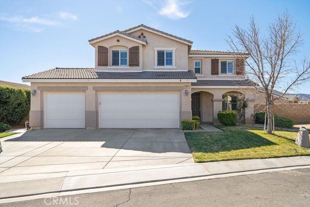 mediterranean / spanish-style house featuring an attached garage, a tile roof, concrete driveway, stucco siding, and a front lawn