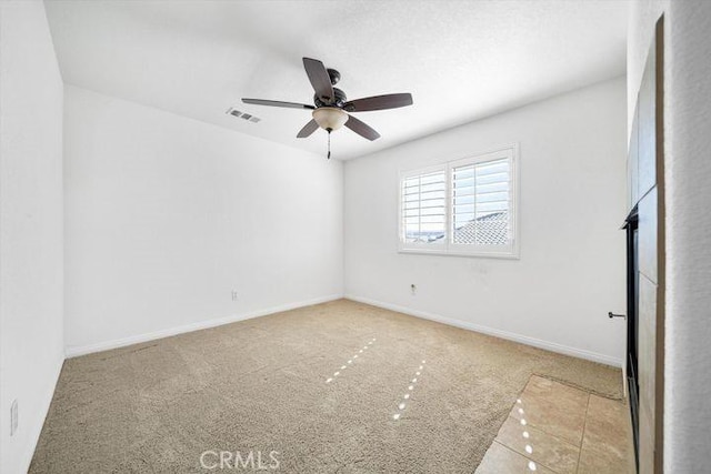 unfurnished room with baseboards, ceiling fan, visible vents, and light colored carpet