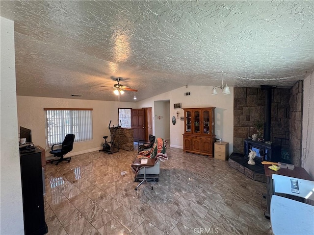 7687 Chase Ave, Hesperia, CA 92345 - living room featuring a wood stove, a textured ceiling, ceiling fan, and vaulted ceiling