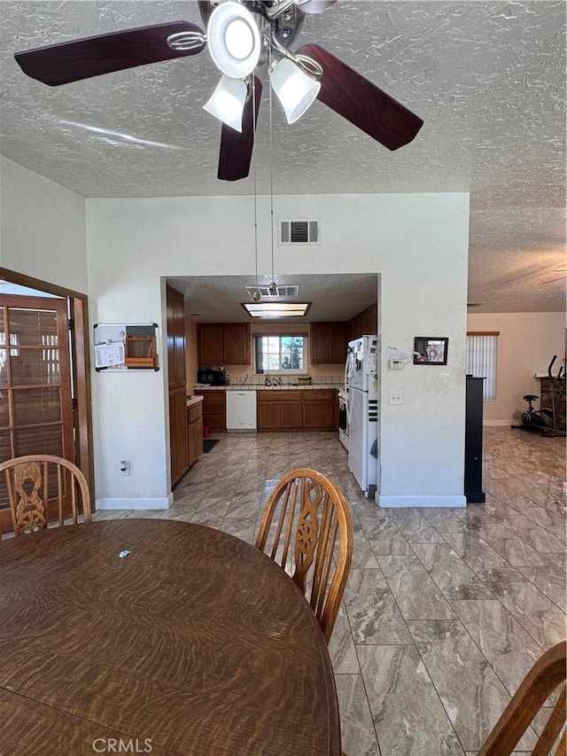 7687 Chase Ave, Hesperia, CA 92345 - dining area featuring a textured ceiling, visible vents, a ceiling fan, and baseboards