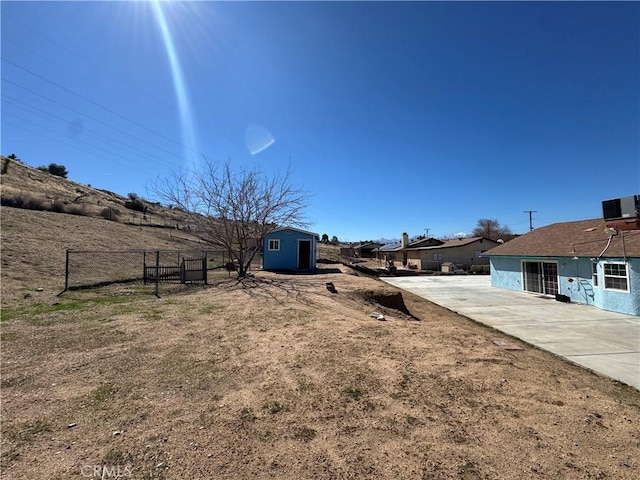 7687 Chase Ave, Hesperia, CA 92345 - view of yard featuring fence, an outbuilding, central air condition unit, a patio area, and a shed