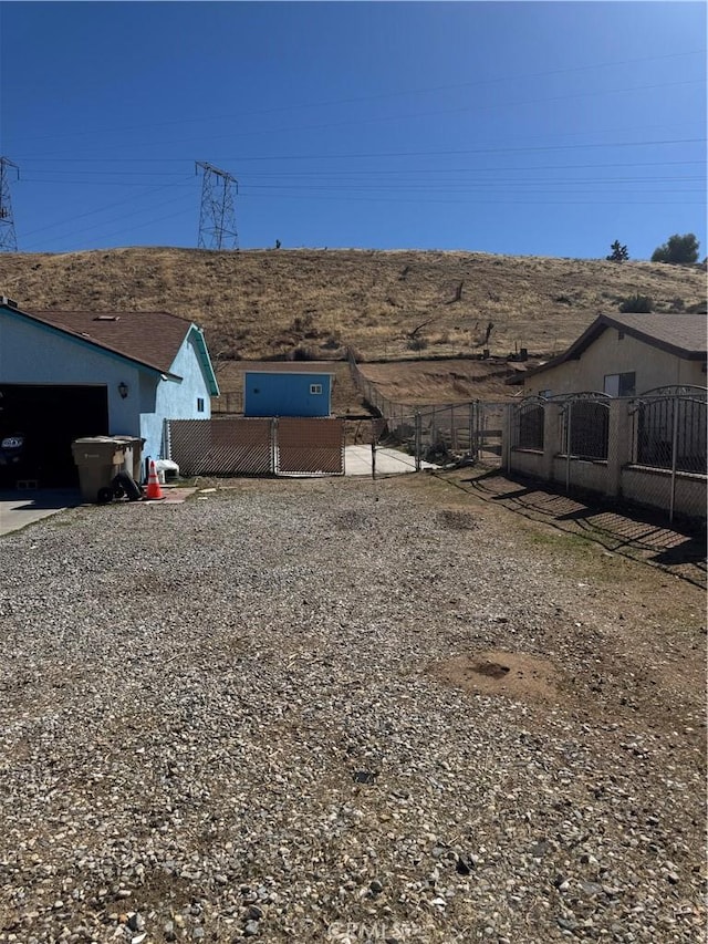7687 Chase Ave, Hesperia, CA 92345 - view of yard featuring fence, a gate, concrete driveway, and an attached garage