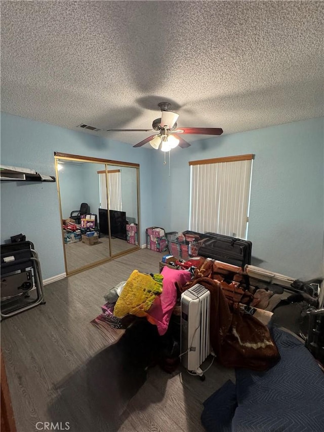 7687 Chase Ave, Hesperia, CA 92345 - bedroom with a textured ceiling, visible vents, ceiling fan, a closet, and wood finished floors