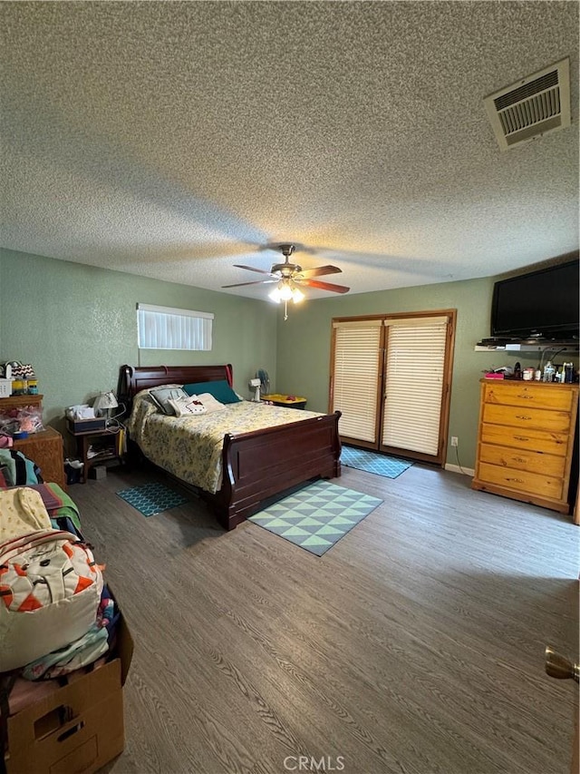 7687 Chase Ave, Hesperia, CA 92345 - bedroom with a textured ceiling, visible vents, wood finished floors, and a ceiling fan