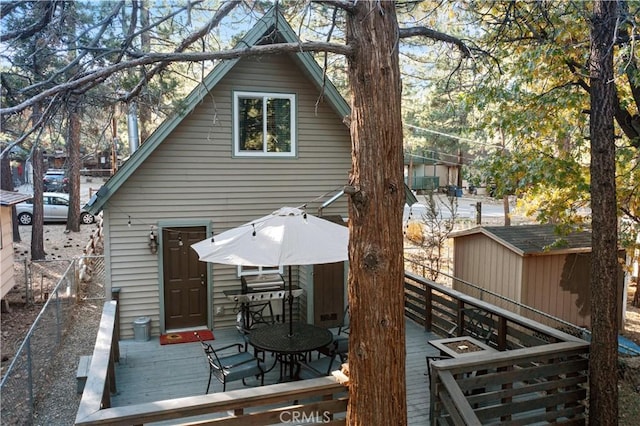 back of house featuring fence and a wooden deck