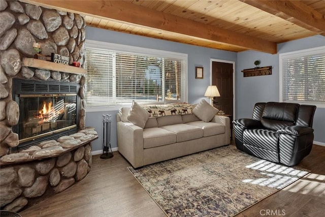 living area featuring a healthy amount of sunlight, wood ceiling, a fireplace, and wood finished floors