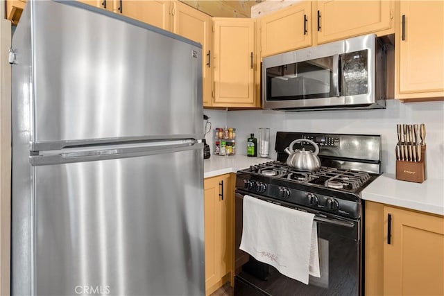 kitchen featuring stainless steel appliances, light countertops, and light brown cabinetry