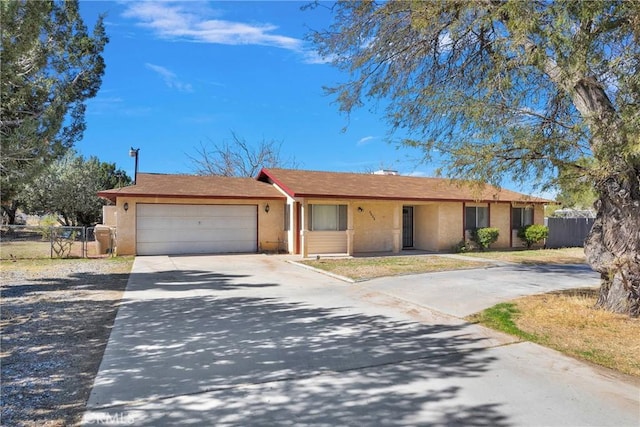 single story home with an attached garage, fence, concrete driveway, and stucco siding