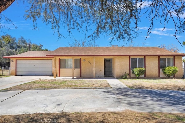 ranch-style home with driveway, an attached garage, and stucco siding