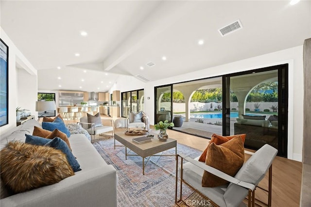 living area with lofted ceiling with beams, light wood-style floors, visible vents, and recessed lighting