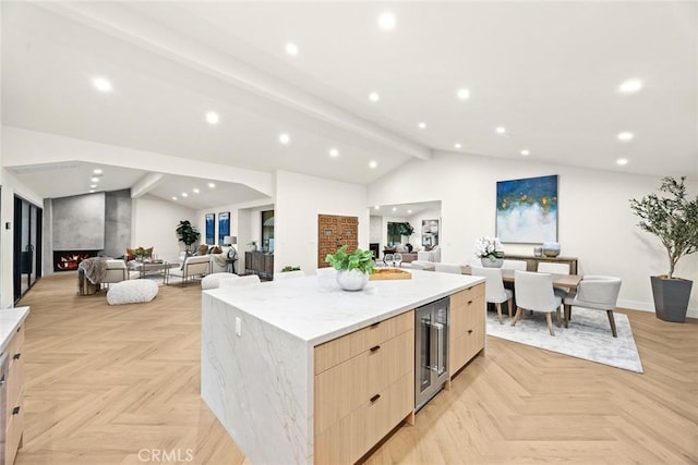 kitchen featuring a large fireplace, lofted ceiling with beams, wine cooler, modern cabinets, and open floor plan