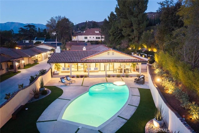 outdoor pool featuring a patio area, a mountain view, and fence