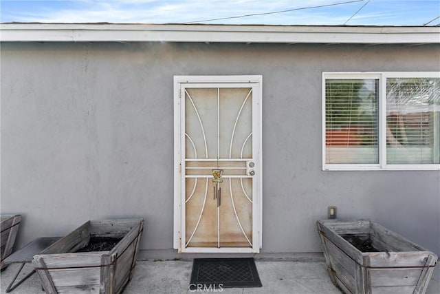 entrance to property featuring stucco siding