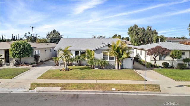 view of front of home featuring a residential view, driveway, and a front lawn