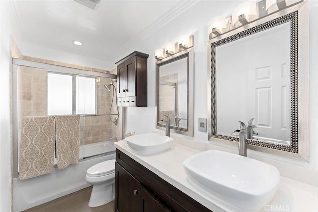 bathroom featuring toilet, bath / shower combo with glass door, a sink, and ornamental molding