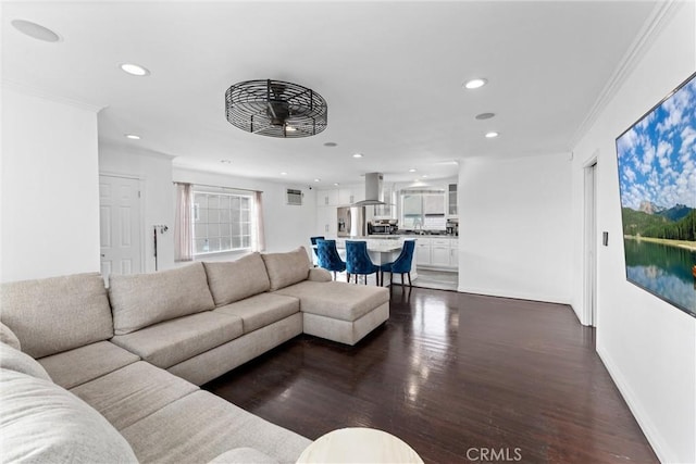 living area with baseboards, ornamental molding, dark wood-type flooring, and recessed lighting