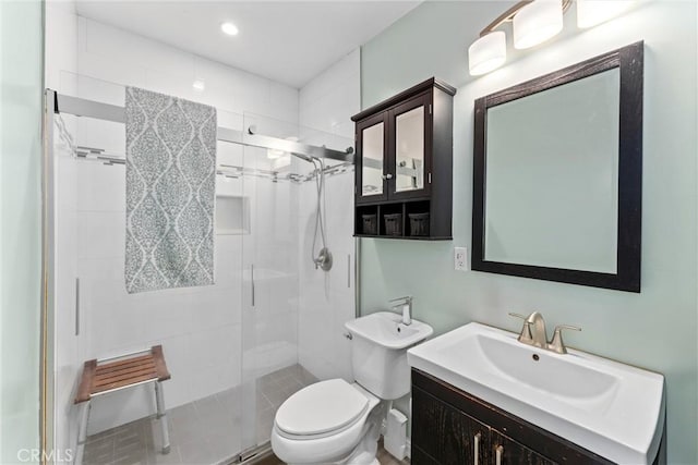 bathroom with a stall shower, vanity, toilet, and recessed lighting