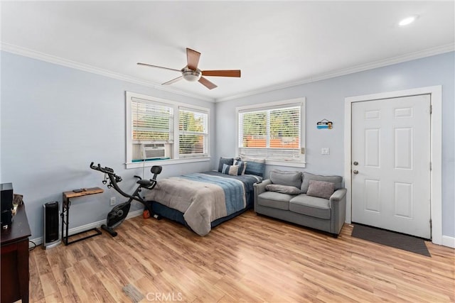 bedroom with cooling unit, crown molding, ceiling fan, light wood-type flooring, and baseboards