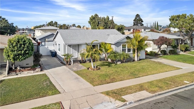 view of front facade with a residential view, driveway, and a front lawn