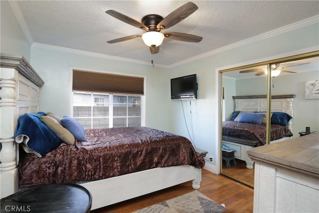 bedroom featuring a textured ceiling, ornamental molding, and wood finished floors