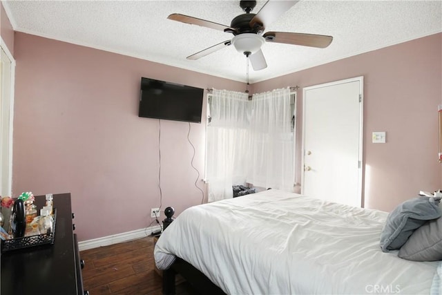 bedroom with dark wood-style floors, a textured ceiling, a ceiling fan, and baseboards