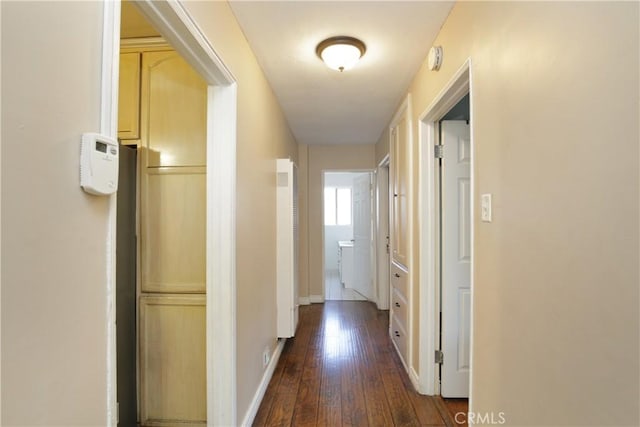 hallway with baseboards and dark wood-type flooring