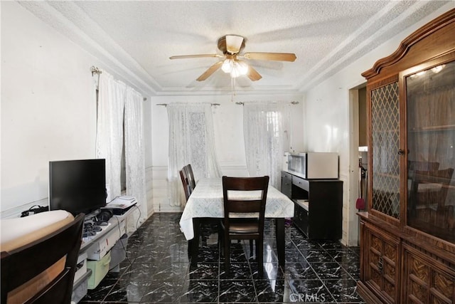 dining room with a textured ceiling, marble finish floor, and a ceiling fan