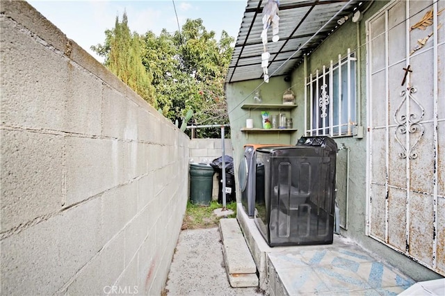 exterior details featuring washing machine and dryer and fence