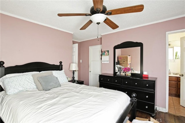 bedroom with a textured ceiling, ornamental molding, dark wood-style flooring, and a ceiling fan