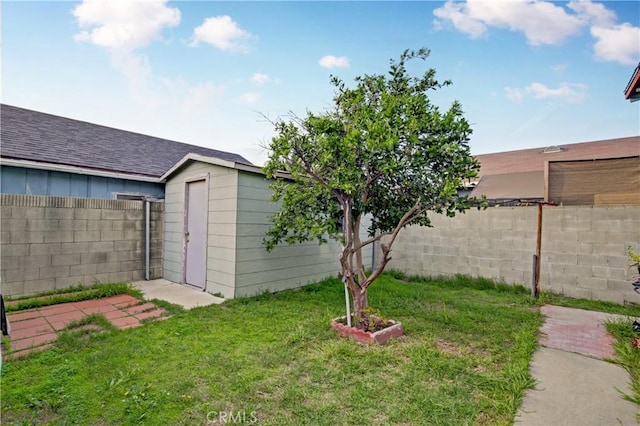 view of yard with an outbuilding, a fenced backyard, and a storage shed