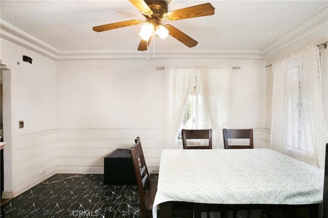 dining area with marble finish floor, crown molding, and a textured ceiling